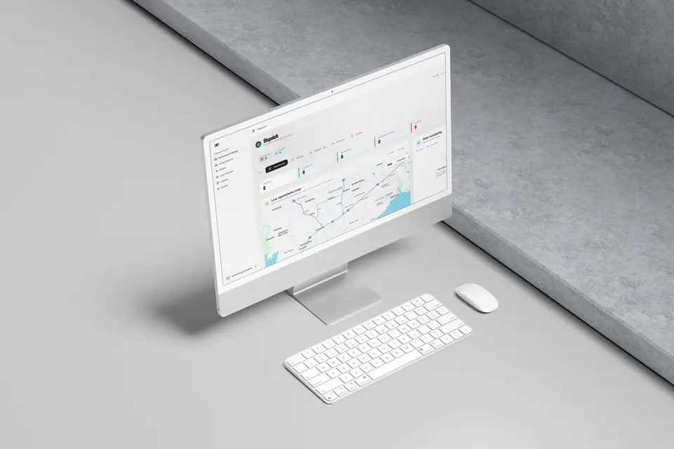 iMac with a keyboard and mouse on a grey surface, showing the BYOB Dispatch portal, with its live operations map and a rider availability panel.