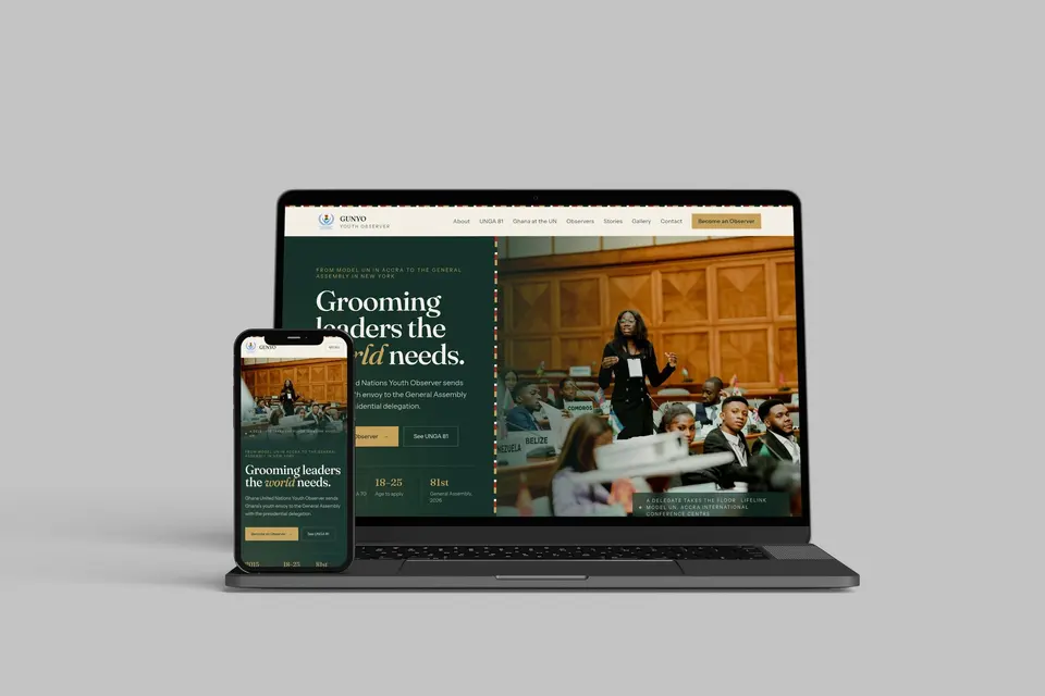 Laptop with a phone in front of it, both showing the GUNYO homepage, Grooming leaders the world needs, with a photograph of a delegate standing to speak in a conference room.